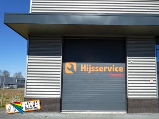 Plakletters op roldeur met logo bestickering